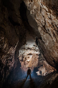 Mid adult man climbing rock in cave