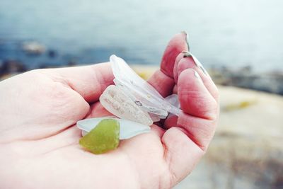 Close-up of hand holding semi-precious gemstones and glass