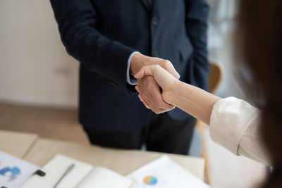 Midsection of business colleagues shaking hands