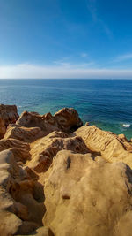 Scenic view of rocky beach against sky