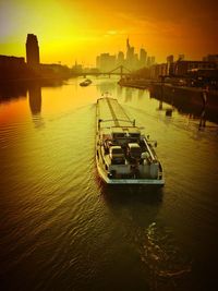 Boats in river at sunset