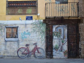 Bicycle on footpath against building in city