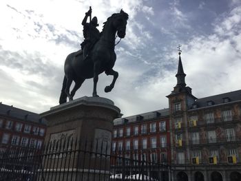 Low angle view of statue against cloudy sky