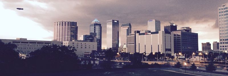 Buildings in city against cloudy sky