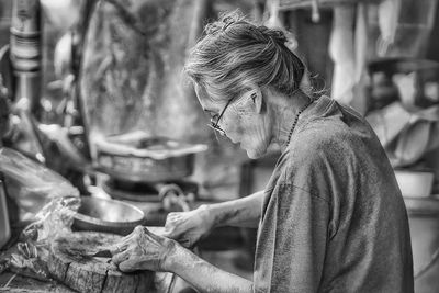 Side view of senior woman preparing food