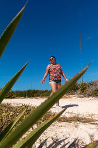 Full length of woman walking against clear blue sky