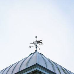 Low angle view of weather vane against sky