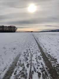 Scenic view of snow covered field against sky