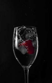 Close-up of wineglass against black background