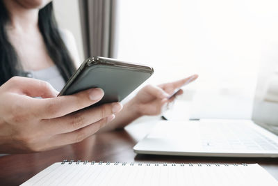 Midsection of woman using mobile phone