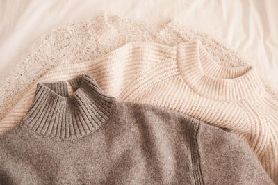 Knitted woolen beige and gray sweaters top view.