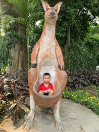 Portrait of boy sitting on tree