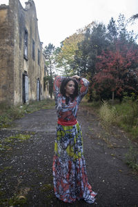 Portrait of woman standing against trees