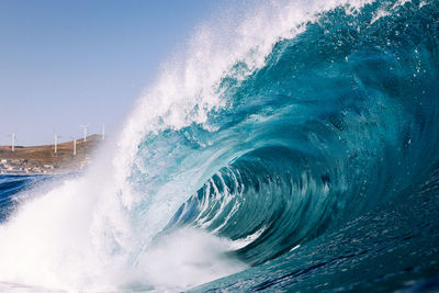 Waves splashing in sea against sky