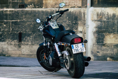 Motorcycle parked on street against wall