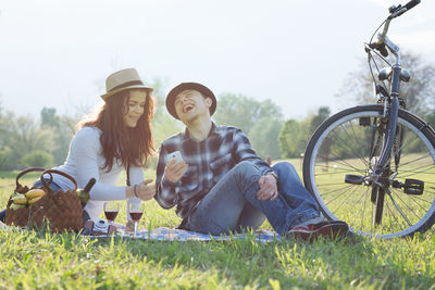 Happy couple on field against sky