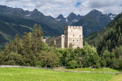 Trees and buildings against mountain range