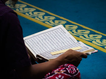 Midsection of woman writing in book