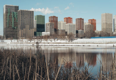 Scenic view of lake by buildings against sky