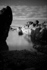 Rock formations by sea against sky