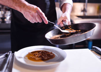 Midsection of man preparing food in kitchen