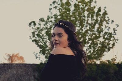 Portrait of young woman against clear sky