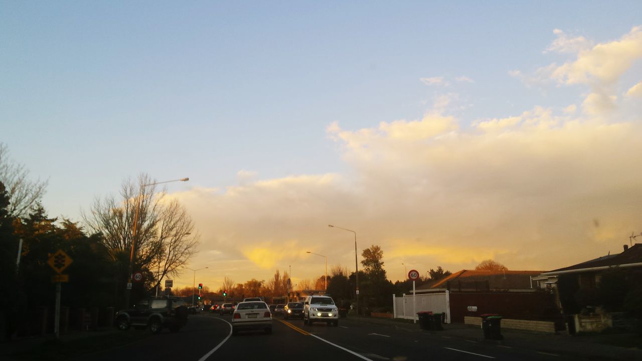 sunset, transportation, road, sky, car, land vehicle, silhouette, cloud - sky, mode of transport, street, tree, the way forward, orange color, scenics, road marking, cloud, nature, beauty in nature, outdoors, on the move