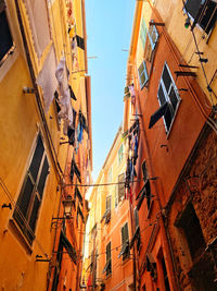 Low angle view of colorful facades with sunshine and blue sky in a narrow street 