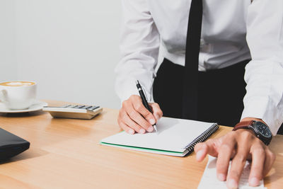 Midsection of businessman working at desk in office