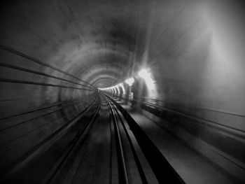 Railroad tracks in illuminated tunnel