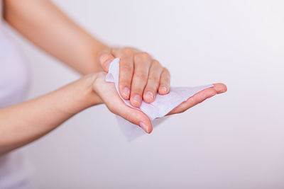 Close-up of woman holding hands over white background