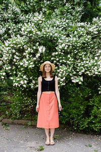 Portrait of woman standing against plants