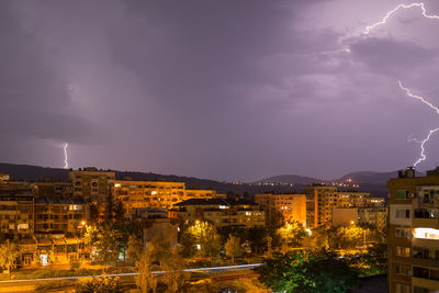 High angle view of illuminated city against sky at night