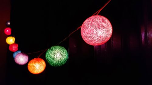 Low angle view of illuminated lanterns hanging in darkroom