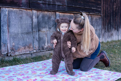 Woman holds her baby from behind. mother and son. child smiles .