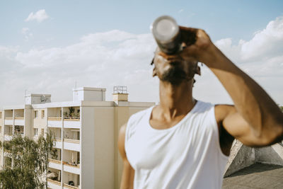 Young man drinking water during sunny sunny day