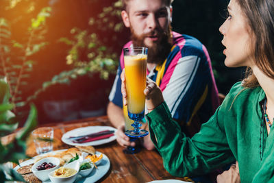 Young couple having drinks while dating in restaurant