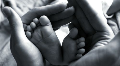 Close-up of woman holding baby feet