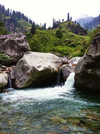 Scenic view of waterfall against sky