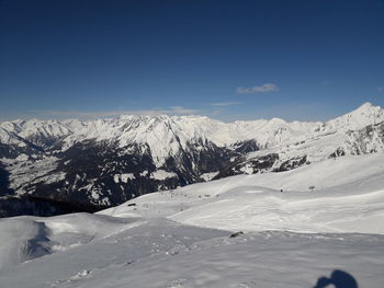 Scenic view of snowcapped mountains against blue sky