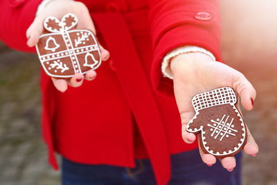 Midsection of woman holding gingerbread cookies during christmas