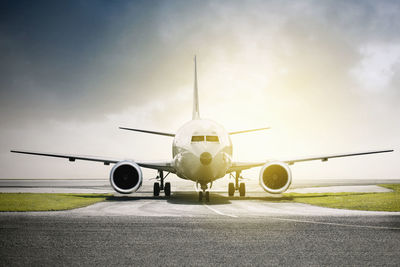 Airplane on runway against sky