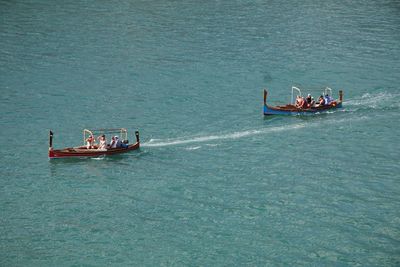 High angle view of people on boats sailing in sea
