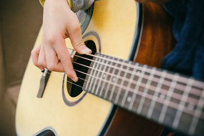 Midsection of man playing guitar