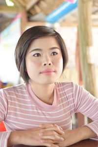 Portrait of a beautiful young woman sitting at restaurant