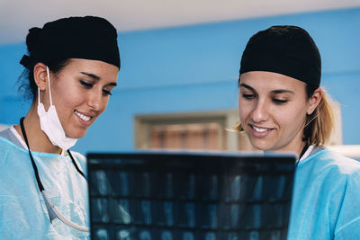 Surgeons examining x-ray image while standing in operating room