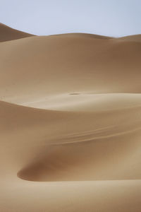 Sand dunes in desert against clear sky