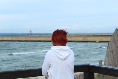 Rear view of woman looking at sea against sky