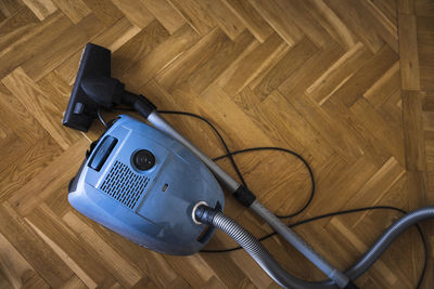 Old-fashioned vacuum cleaner on wooden floor