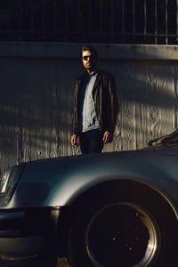 Young man standing in car